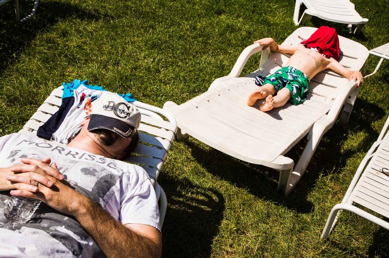 quiet moment of dad and his son laying in beach chairs, with similar body language