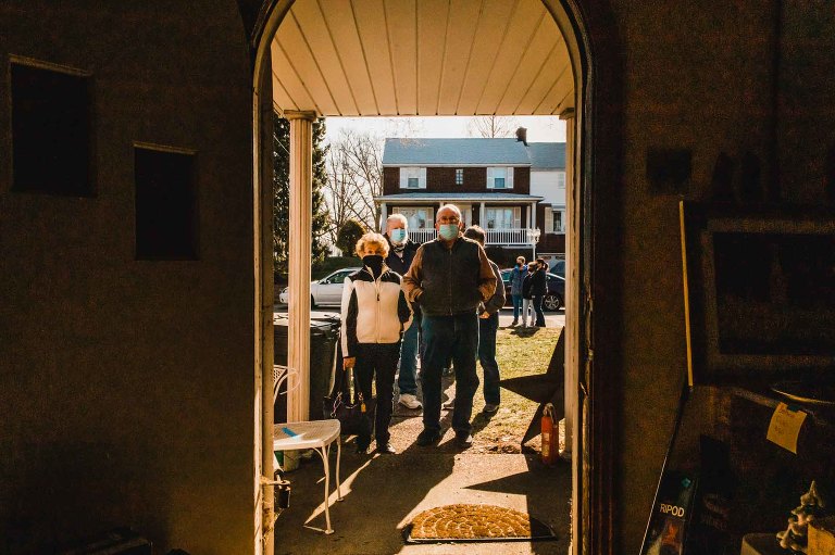 line of people outside estate sale front door waiting to enter
